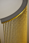 Nickel Plated or Aluminum or silver colored Faceted metal ball chain hanging vertically on circular track and yellow light shining onto the system